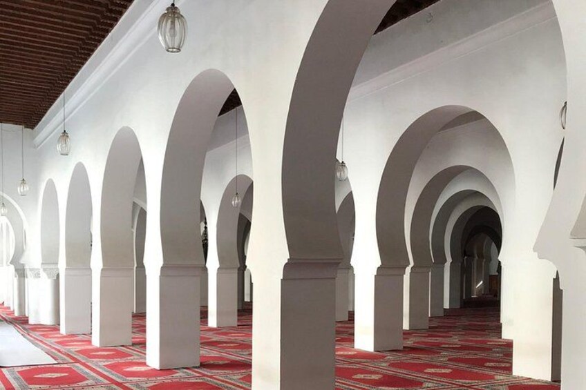 Un pasillo con arcos y lámparas colgantes. 4
