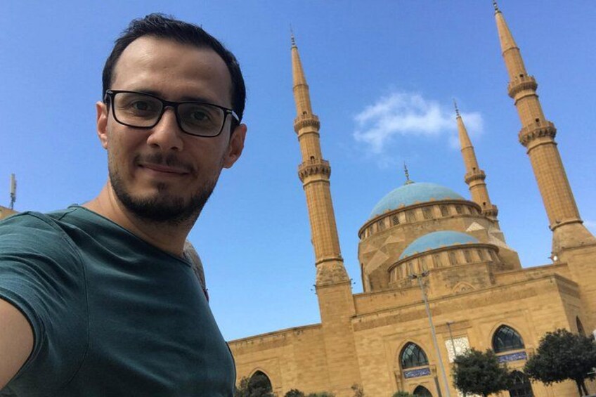 Una persona tomándose un selfie con una mezquita de fondo. 5