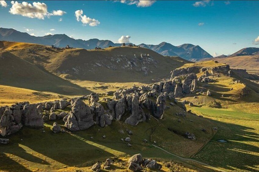 A mountainous landscape with a stone wall and a clear sky. 4