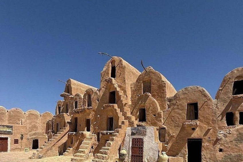 A desert landscape with ancient, multi-tiered stone structures. 1