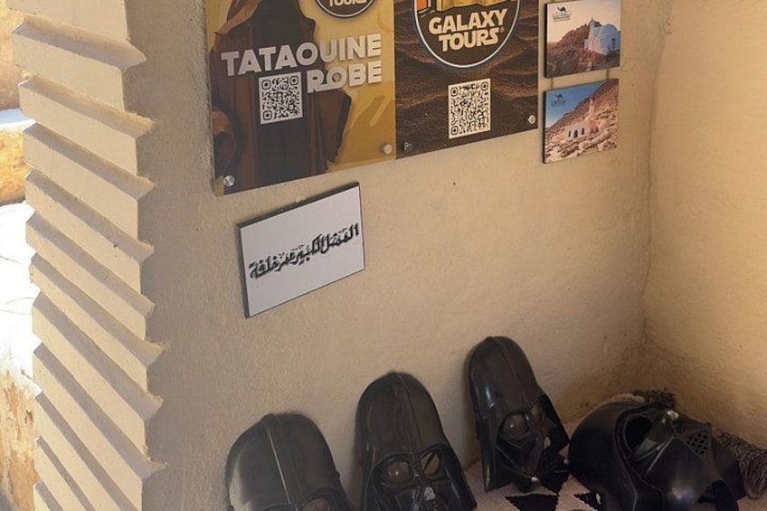 A wall with posters, a sign, and a pair of shoes. 2