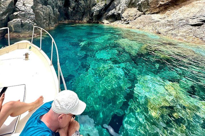 A boat on clear turquoise water with rocky shores. 5
