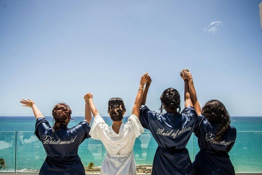 A group of people standing by a beach with the ocean in the background. 1