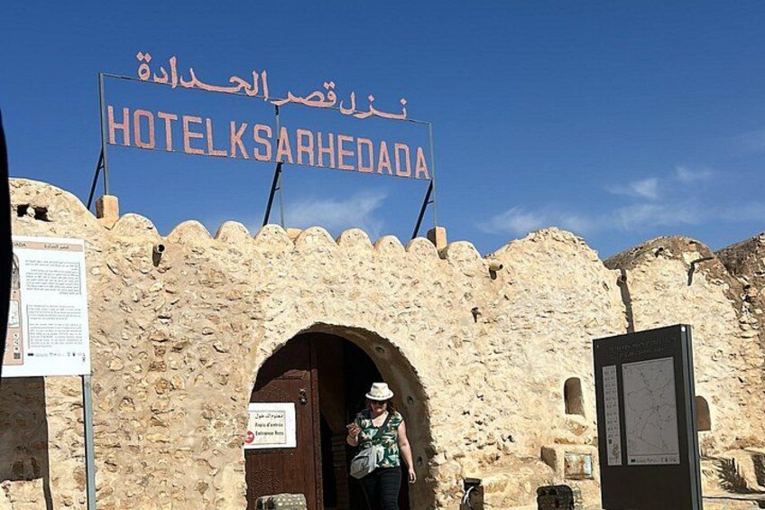 Un edificio de piedra con un letrero que dice 'HOTELKSARHEDA' y una persona parada en frente. 2