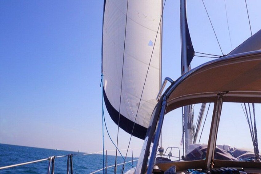A sailboat with a clear sky and calm sea. 4