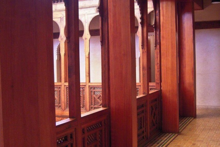 A wooden corridor with arches and a tiled floor. 4