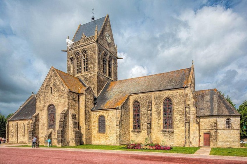 A historic stone church with a bell tower, arched windows, and a red brick facade. 4