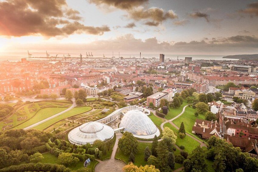 A cityscape with a large park, two domed structures, and industrial buildings in the background. 4