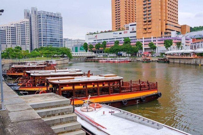 Un río con barcos amarrados, un puente y edificios al fondo. 4