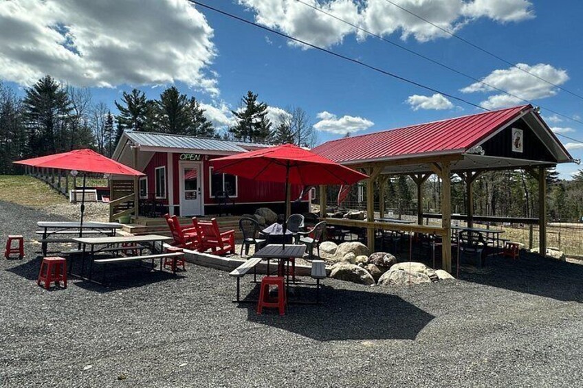 Un pavillon à toit rouge doté d’une terrasse, un bâtiment avec un auvent rouge et un sol en gravier. 5