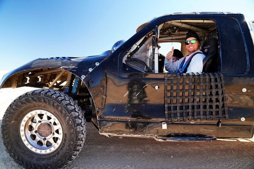 A modified black pickup truck with large off-road tires and a raised suspension. 5