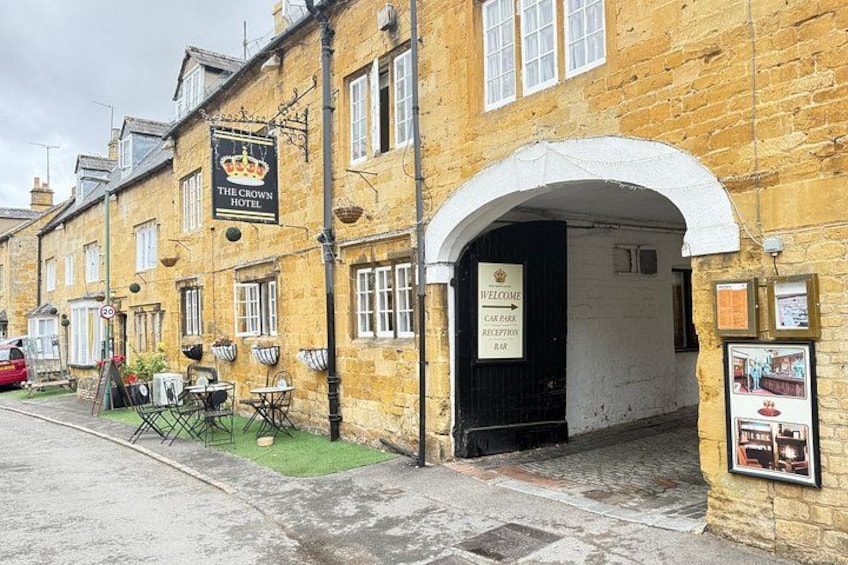 A historic building with a sign for 'The Crown Hotel' and a car park reception bar. 2