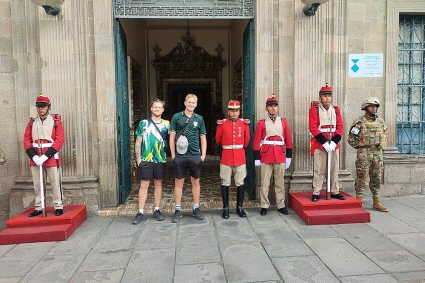 A group of people standing in front of a building with columns. 4