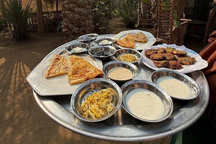 Una bandeja de metal con diversos platos, incluyendo pan plano, curry y arroz. 5