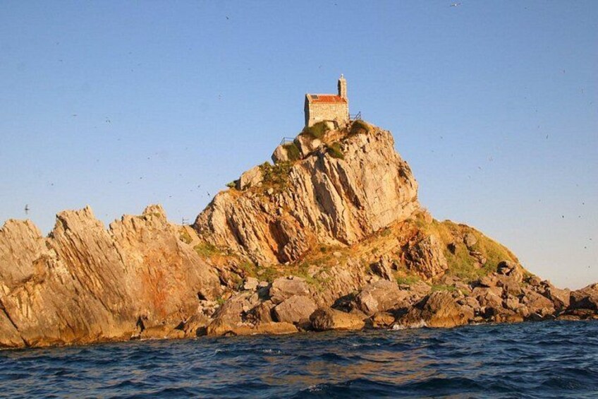 Una isla rocosa con un faro en la cima. 4