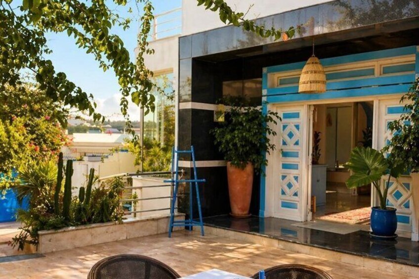 A modern building with blue accents, a large potted plant, and a hanging light fixture. 5