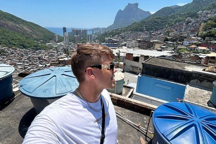 A person on a rooftop overlooking a cityscape with buildings and a prominent mountain in the background. 3