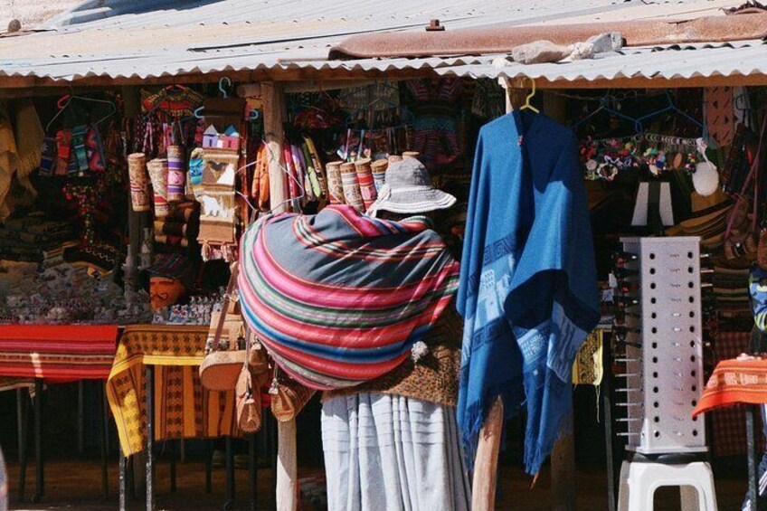 A market stall with colorful textiles and a person standing in front. 3