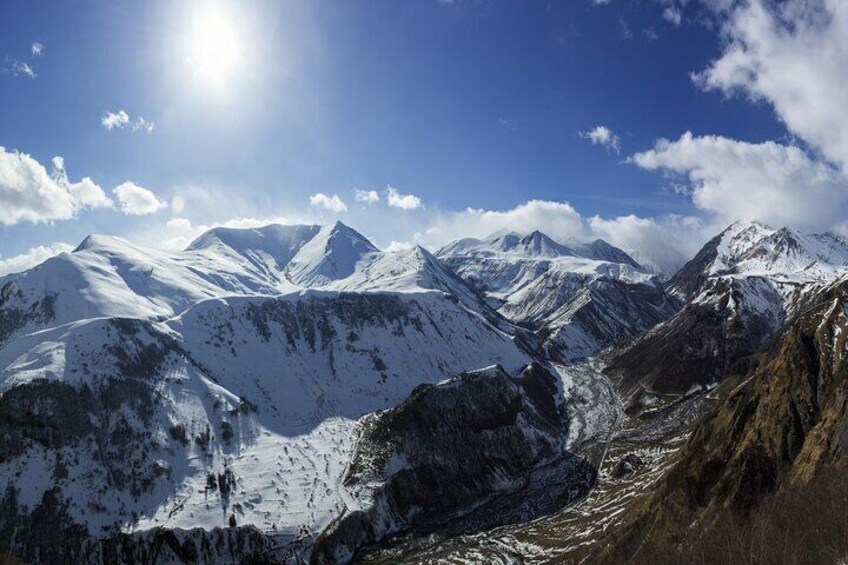 Una catena montuosa innevata sotto un cielo azzurro limpido. 4
