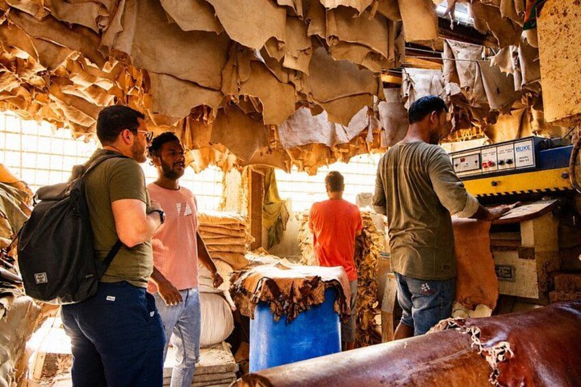 A market with leather goods and a person operating a machine. 2