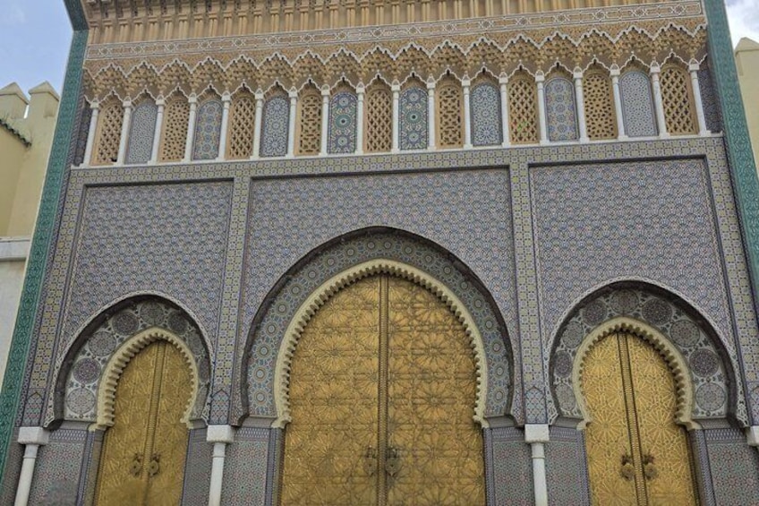 Un edificio con elaborate decorazioni in maiolica e tre grandi porte scenografiche. 5