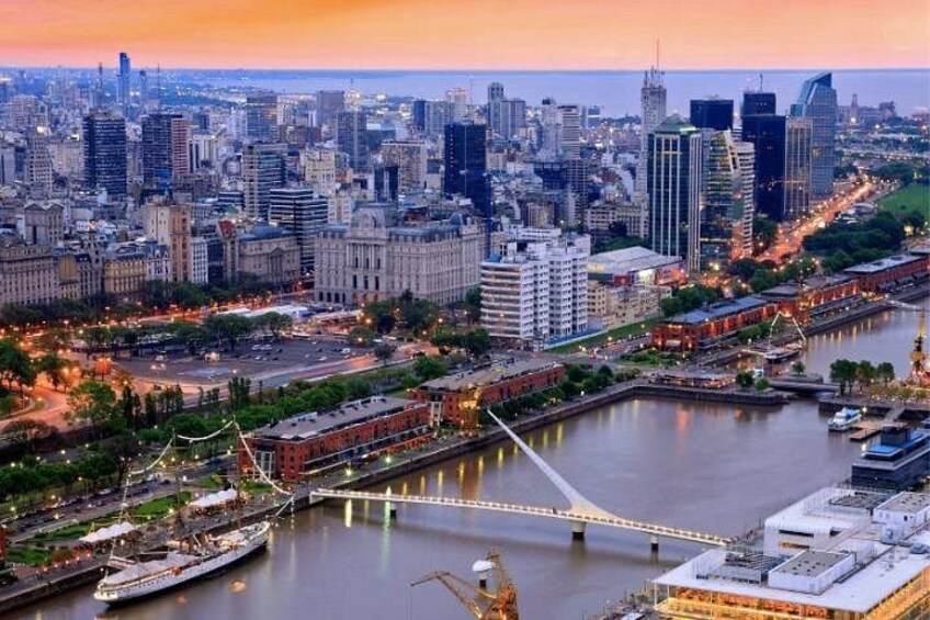 A cityscape with a river, a bridge, and a cruise ship. 2