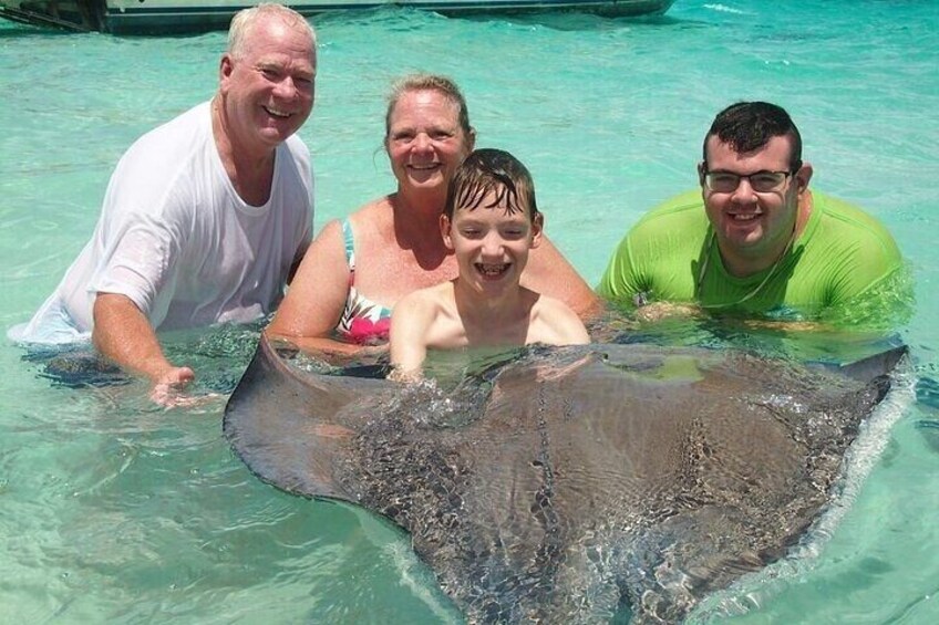 Eine Gruppe von Menschen in einem Pool, zusammen mit einem Manta-Rochen. 3