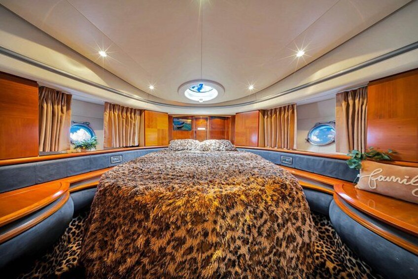 A luxurious interior with a large bed, wooden paneling, and a circular skylight. 5