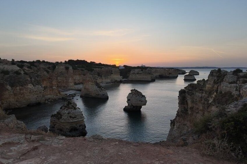 Un paisaje costero con formaciones rocosas y agua tranquila al atardecer. 3