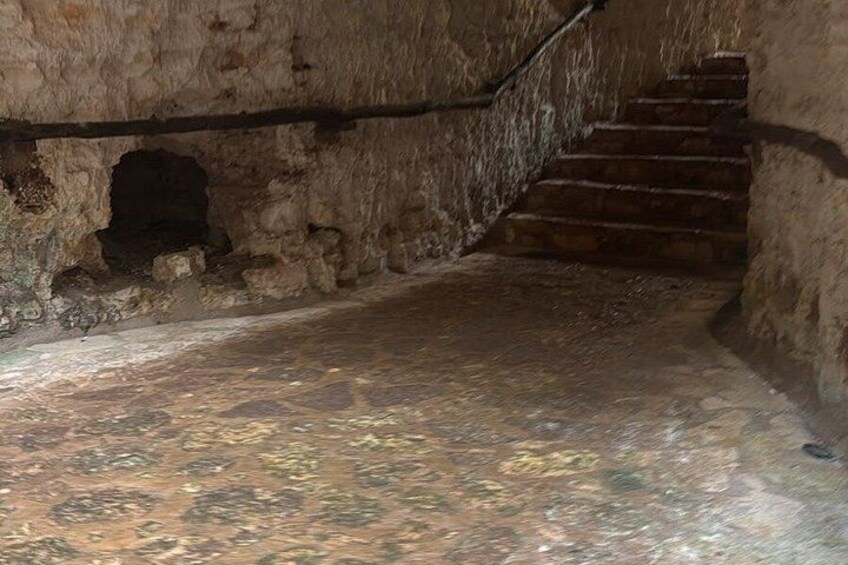 En stentrappa i en grotta med ett ojämnt och oregelbundet golv. 5