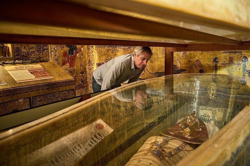 Un hombre observando artefactos en una vitrina de museo. 3