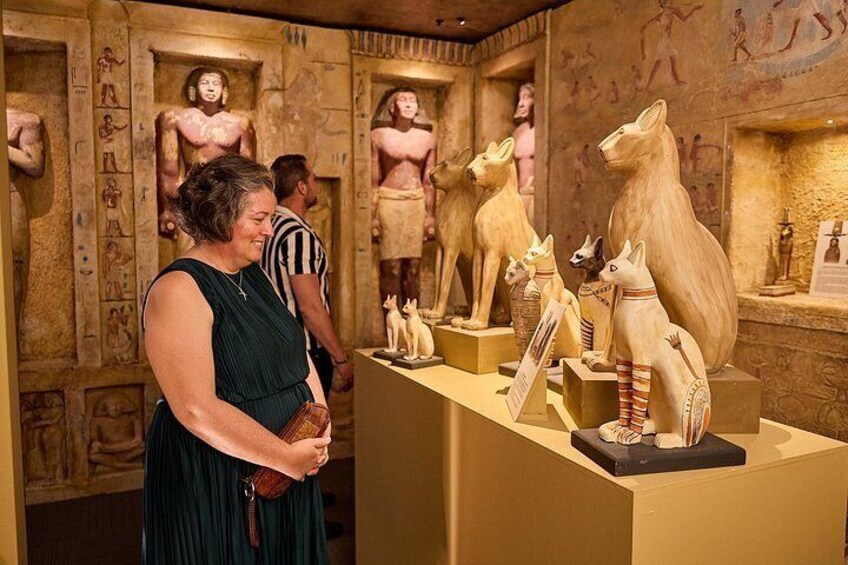 Una exhibición de museo con artefactos del antiguo Egipto, incluyendo estatuas y jeroglíficos. 5