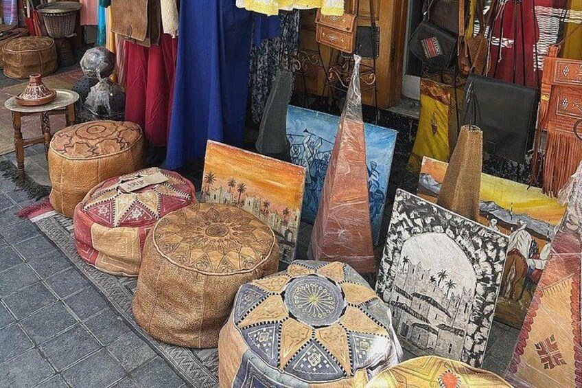 Un puesto de mercado con diversos textiles, cojines y objetos decorativos. 5
