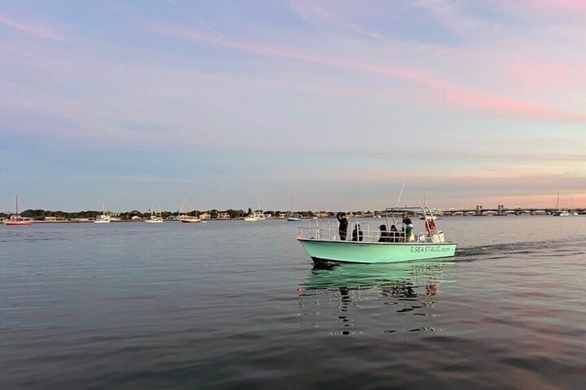 Un bateau vert sur une eau calme, sous un ciel dégagé. 2