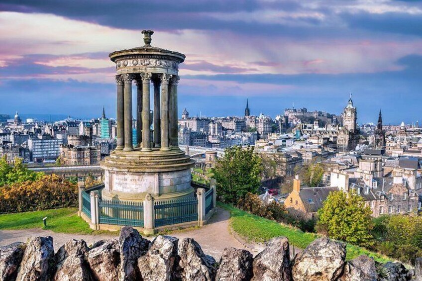 A cityscape with a prominent monument in the foreground and a historic building in the background. 4