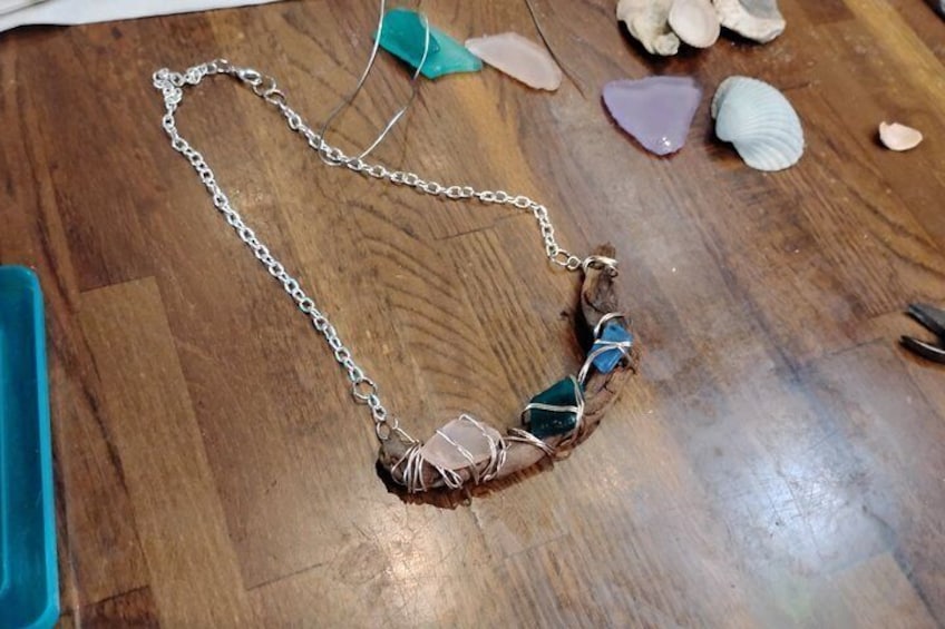 A necklace with a chain and a pendant made of stones and wire. 5