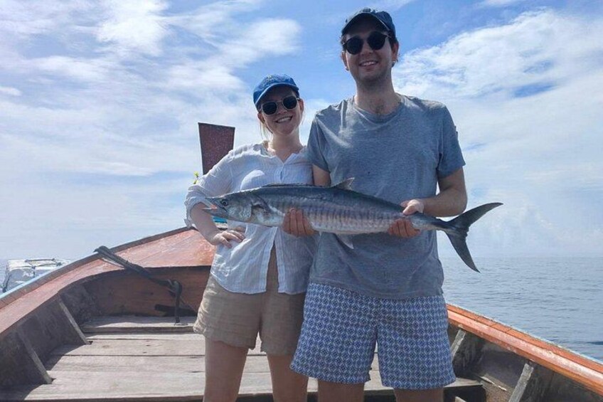 To personer i en båd holder et fisk. 2