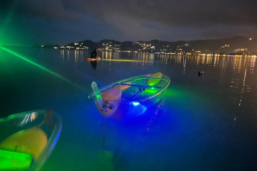 A boat with colorful lights on a calm body of water at night. 2