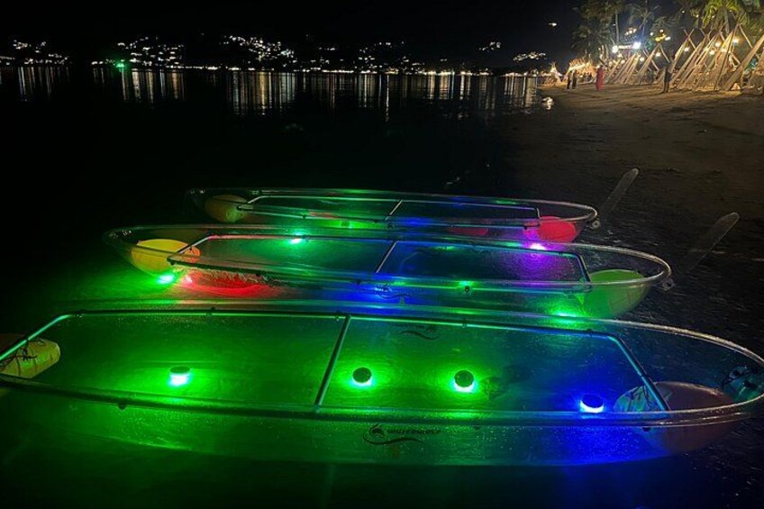 Several illuminated boats on a dock at night. 1