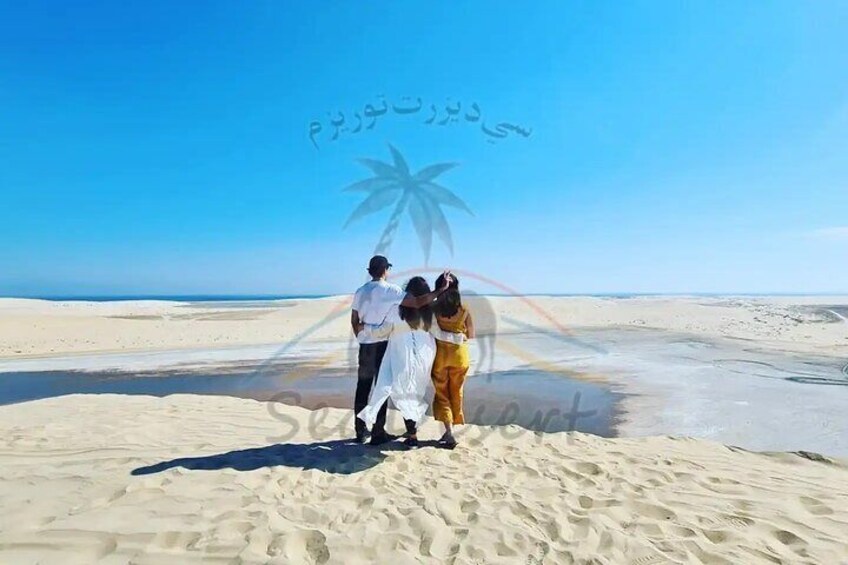 A group of people on a sandy beach with a clear sky. 3