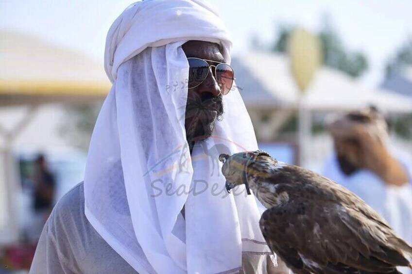 A person wearing a white headscarf holding a bird. 5