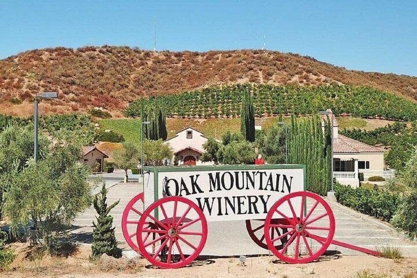 A sign for Oak Mountain Winery with a red wagon wheel. 5