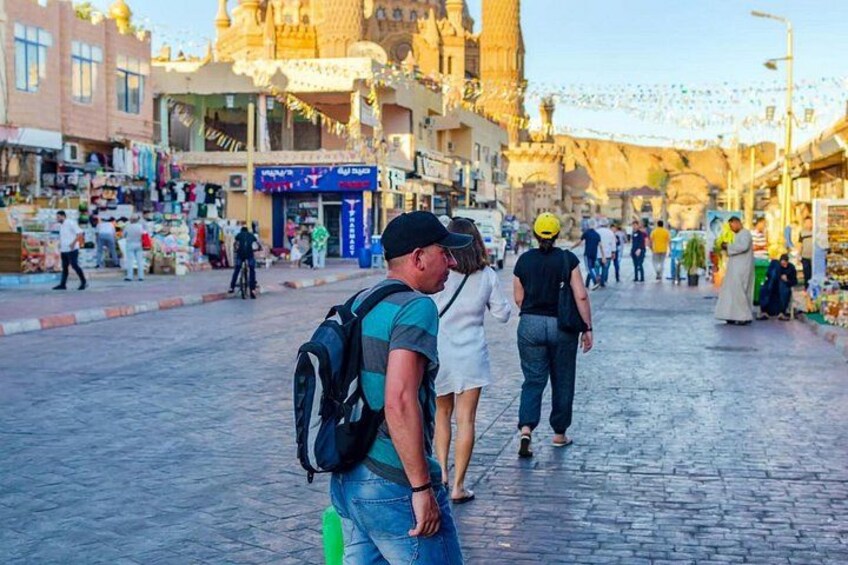 A cobblestone street with shops and people walking. 2