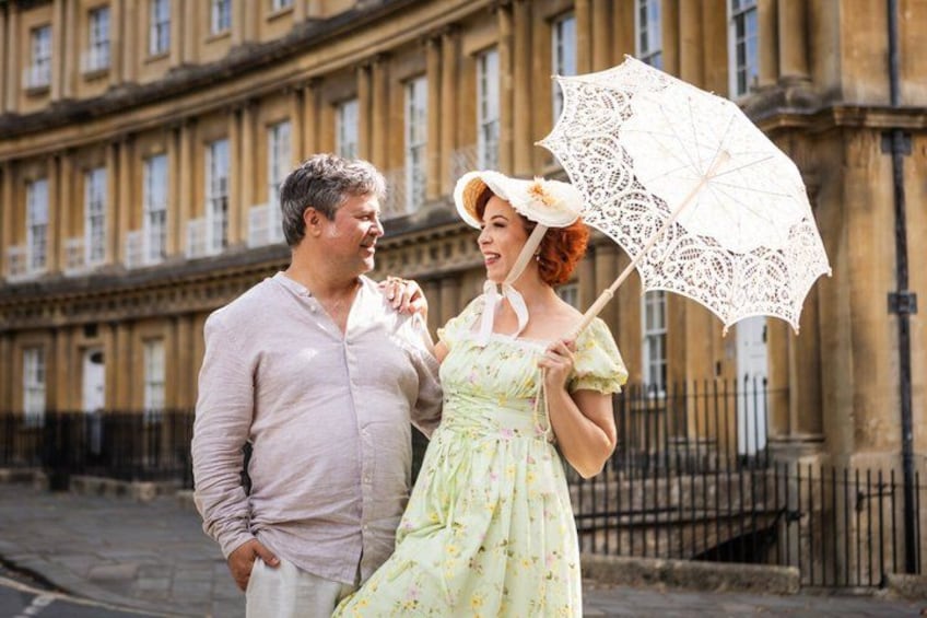 A man and a woman standing in front of a historic building with a wrought iron fence. 4