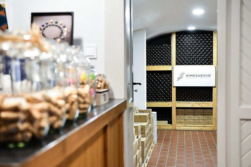 A bakery counter with pastries and a wine cellar with a sign. 5
