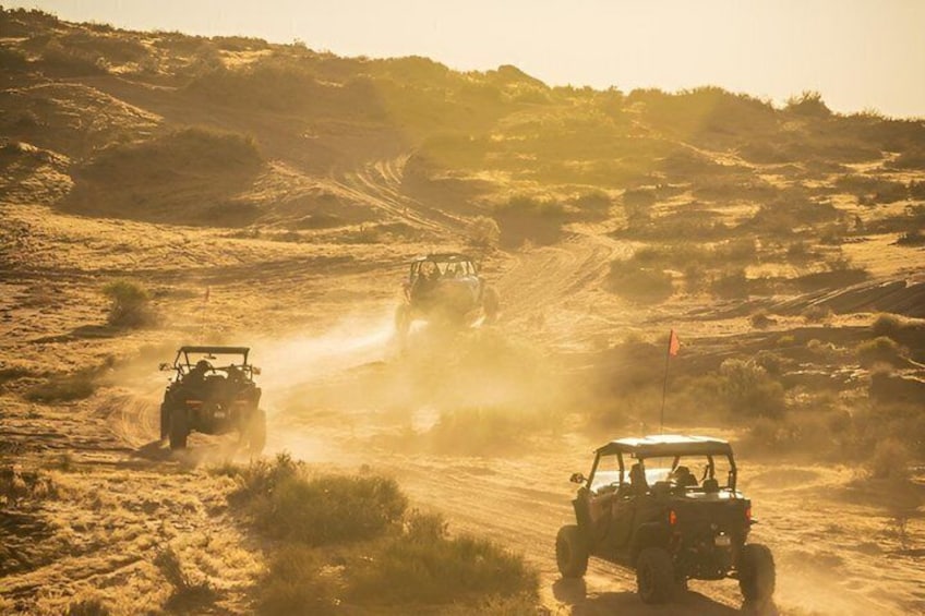Off-road vehicles on a dusty trail in a desert landscape. 2