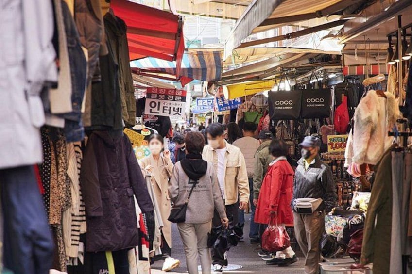 Un mercado techado concurrido, con varios puestos que venden ropa y accesorios. 4