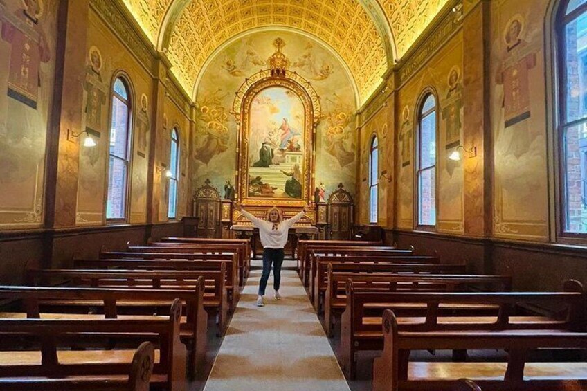 L’intérieur d’une église avec des bancs en bois, un autel central et une voûte. 4