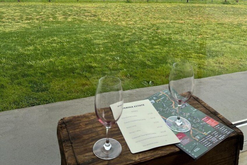 Deux verres à vin sont posés sur une table en bois, accompagnés d’un menu et d’une carte. 2