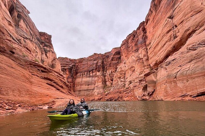 A narrow canyon with red rock walls and a river. 1